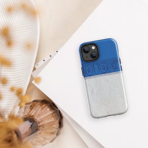 May include: A blue and silver phone case with a decorative design. The case has a textured silver bottom half and a blue top half with a silver decorative band.