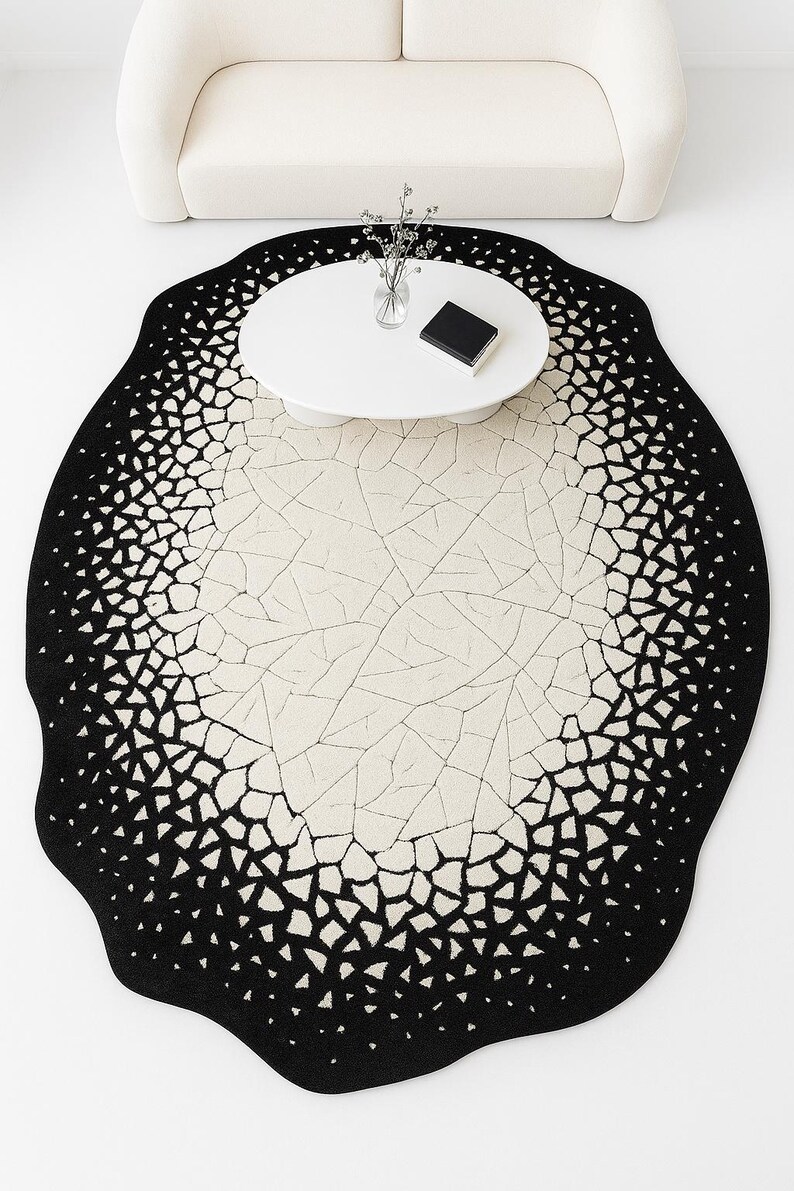 Top view of modern black and ivory cracked eclipse rug laid flat showing abstract circular design.