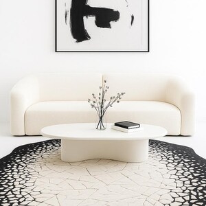Close-up texture shot showing soft hand-tufted wool and silk blend fibers in black and ivory pattern.