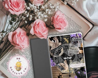 Op de afbeelding: Een Amazon Kindle e-reader en een doorzichtige hoes met een drakenontwerp, met tekst en illustraties. Roze rozen en gipskruidbloemen zijn gerangschikt rond een open boek. Een vinylplaat is zichtbaar op de achtergrond.