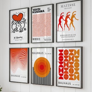 May include: Six framed art prints with black frames, featuring abstract designs and text. The prints include works by K. Haring, Yayoi Kusama, and Bauhaus. The colour palette includes red, orange, and black, suitable for a modern interior.