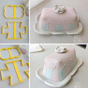 May include: A collage of handmade pottery items. Includes yellow cookie cutters in the shape of a butterfly and a cross. Also, a pink and blue butter dish with a white flower on top, sitting on a white plate. The pottery is from Waiyi Pottery.