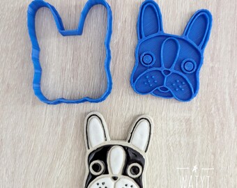 May include: Three French bulldog-themed items. A blue plastic cookie cutter in the shape of a French bulldog head, a blue plastic cookie cutter in the shape of a French bulldog head, and a ceramic French bulldog head with black, white, and pink details.