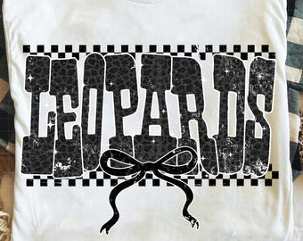 May include: White t-shirt with the word "LEOPARDS" in large, distressed black letters with leopard print fill. A black bow is centered below the text, and the design is framed by a black and white checkered border.