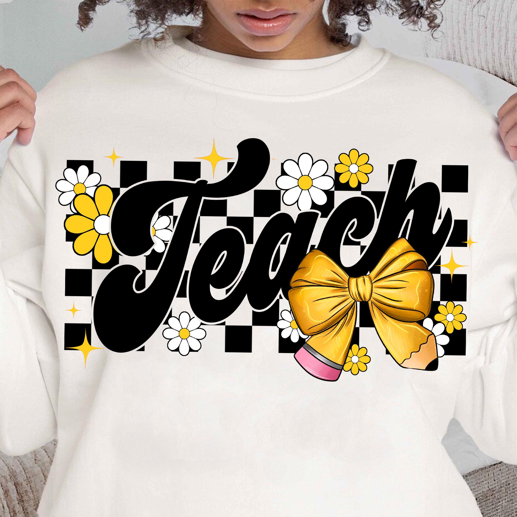 May include: White sweatshirt with a black and white checkered background. The word "Teach" is written in a black, retro font with a yellow bow and pencil. The design is accented with yellow and white daisies.