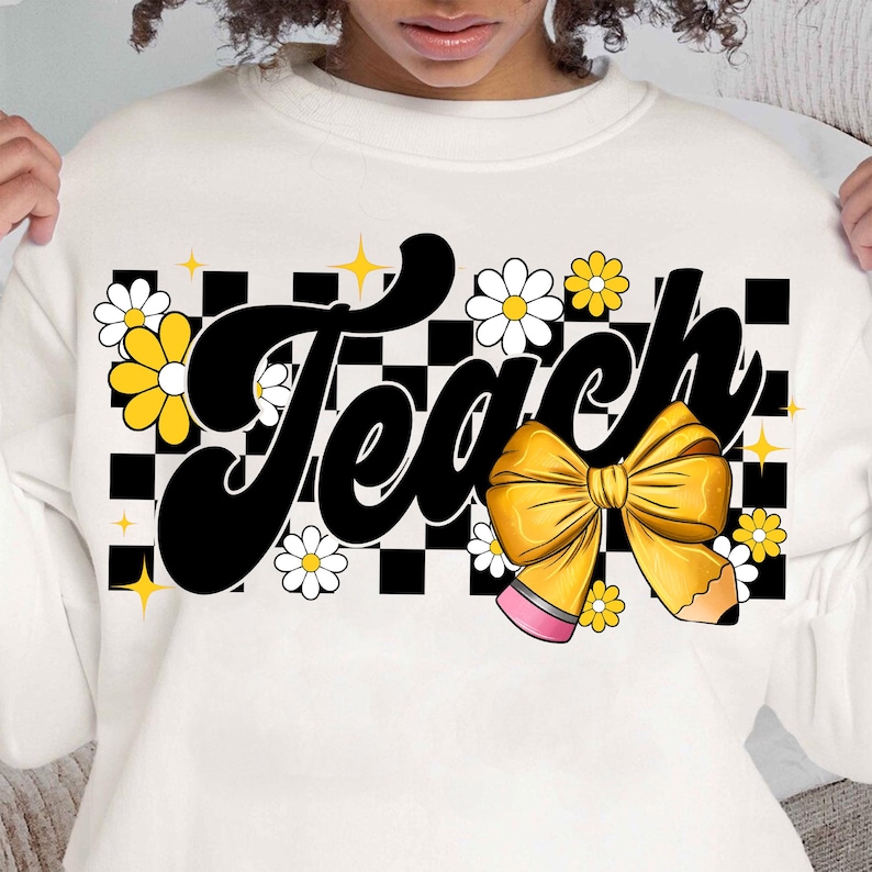 May include: White sweatshirt with a black and white checkered background. The word "Teach" is written in a black, retro font with a yellow bow and pencil. The design is accented with yellow and white daisies.