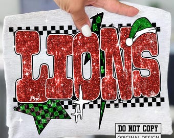 May include: A light grey t-shirt with the word "LIONS" in large, red glitter letters with a white outline. The design includes a green and black checkered star, a green lightning bolt, and a Santa hat on the letter "S". The text "DO NOT COPY ORIGINAL DESIGN" is at the bottom.