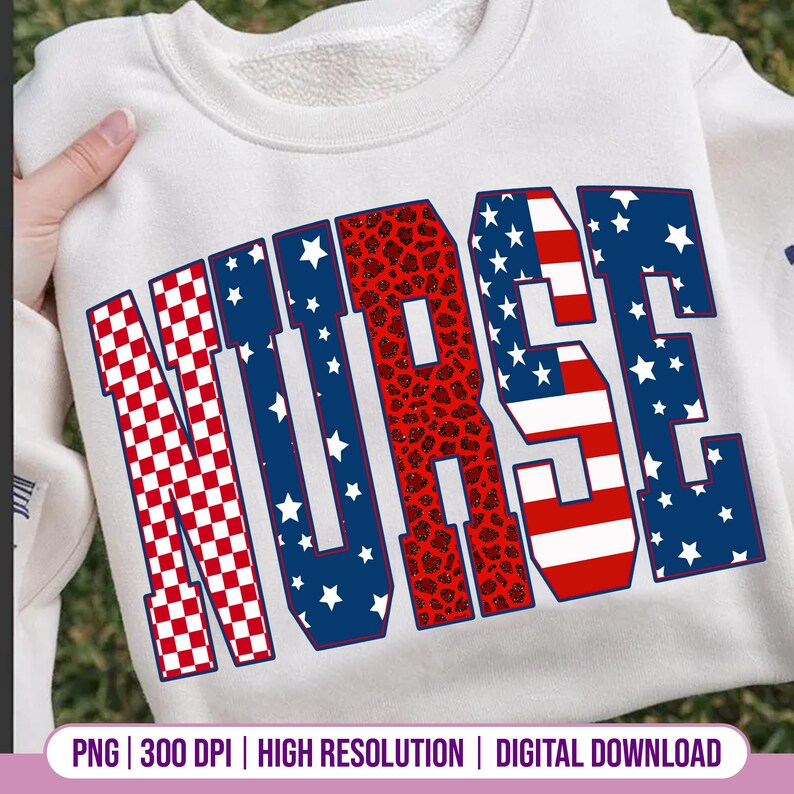 May include: White sweatshirt with the word "NURSE" in large, bold letters. The letters have a patriotic design, with red and white checkered patterns, blue with white stars, and a red leopard print. The sweatshirt is held by a hand.