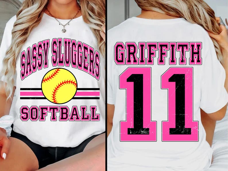 May include: White t-shirt with pink and black text that says "Sassy Sluggers Softball" and a softball graphic on the front. The back of the shirt has pink and black text that says "Griffith 11".