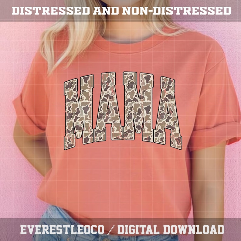 May include: A coral-colored t-shirt with the word "MAMA" in large, block letters across the front. The letters are filled with a camouflage pattern in shades of brown and tan. The shirt has rolled-up sleeves and the text "DISTRESSED AND NON-DISTRESSED" and "EVERESTLEOCO / DIGITAL DOWNLOAD" are printed on the top and bottom.