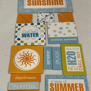 May include: A collection of colorful summer-themed decorative tiles. The tiles feature phrases like "You are my sunshine," "Just add water," and "A taste of summer." Designs include a sun, stars, and polka dots. Colors include orange, blue, and white.