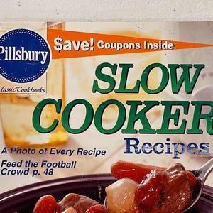 May include: A Pillsbury cookbook titled "Slow Cooker Recipes" with a photo of a recipe on the cover. The cover features the Pillsbury logo, text that says "Save! Coupons Inside", and the text "Feed the Football Crowd p. 48".
