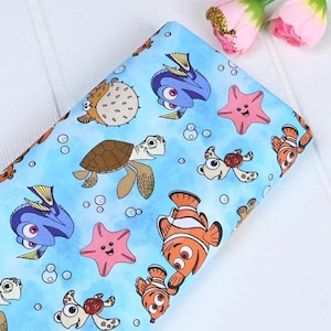 May include: Light blue fabric featuring cartoon sea creatures like clownfish, starfish, and turtles. The design includes bubbles and various sea life characters. The fabric is suitable for crafting and sewing projects.