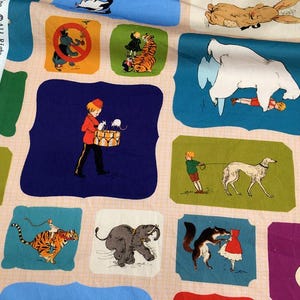 Peut inclure: Tissu à motifs avec des illustrations colorées répétitives. Les illustrations comprennent un garçon avec un tambour, un tigre, un ours polaire, un chien et d'autres personnages fantaisistes. Le fond est de couleur rose clair.