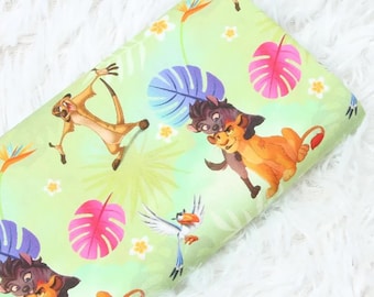 May include: Pale green fabric printed with characters from The Lion King. The design includes Simba, Timon, Pumbaa, and Zazu, alongside tropical leaves and flowers. Ideal for crafting projects.