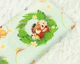 May include: Light blue fabric featuring a circular design with Timon and Pumbaa surrounded by green leaves and yellow flowers. The fabric also includes illustrations of Simba, tropical flowers, and other decorative elements.