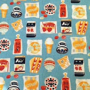 Könnte beinhalten: Hellblauer Stoff mit einem sich wiederholenden Muster japanischer Lebensmittel. Das Design umfasst Eiswaffeln, Sandwiches, Milchkartons und verpackte Snacks in verschiedenen Farben. Der Text im Bild ist auf Japanisch.