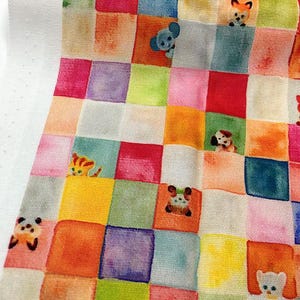 May include: A colorful fabric with a patchwork design featuring various cartoon animals. The squares are in shades of pink, orange, green, blue, and purple. Animals include a fox, koala, dog, cat, panda, and bear.