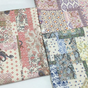 Könnte beinhalten: Nahaufnahme von mehreren Stoffmustern mit einem Patchwork-Design. Die Stoffe weisen Blumen- und Paisley-Muster in Rosa-, Creme-, Blau- und Lilatönen auf. Die Stoffe sind wahrscheinlich für Quilt- oder andere Bastelprojekte bestimmt.