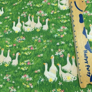May include: Fabric with a green background featuring white geese and colorful flowers. A wooden ruler with blue accents and the words "Happy Party" is on the right side of the image.