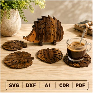 May include: A dark brown wooden hedgehog-shaped holder containing several dark brown wooden coasters shaped like monstera leaves. One coaster sits under a glass cup filled with dark coffee. The text SVG, DXF, AI, CDR, PDF is visible.