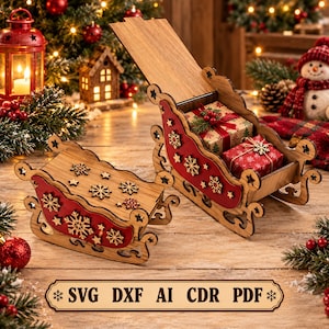 May include: Two decorative wooden sleighs featuring red side panels adorned with laser-cut wooden snowflake motifs. One sleigh is open, containing two small gift boxes wrapped in patterned paper. A rectangular label displays the text SVG DXF AI CDR PDF.