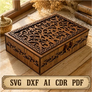 May include: A rectangular wooden box featuring intricate laser-cut filigree patterns on the lid and sides. The dark brown wood displays a natural grain, and the box includes a small latch. A rectangular label at the bottom displays the text SVG DXF AI CDR PDF.