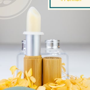 Peut inclure: Un ensemble de rouges à lèvres avec un rouge à lèvres jaune clair dans un tube en argent et en bambou. L'image comprend le texte "Lippenstift-Set 4 Hülsen 4 Formen" et "Lippenstifte selber machen!" avec des fleurs jaunes.