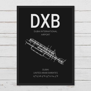 May include: A black and white airport map print with the text "DXB" in large white letters. The text "Dubai International Airport" is below the airport code. The map shows the layout of Dubai International Airport in the United Arab Emirates. The coordinates 25&deg;15'06.9"N 55&deg;22&prime;04.5"E are listed below the airport name.