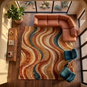 May include: An overhead view of a living room with a brown leather sectional sofa, two teal armchairs, and a colorful area rug. The rug features a wavy pattern in shades of orange, brown, blue, and cream. A wooden shelf and potted plant are also visible.
