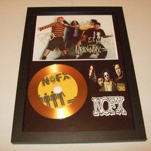 May include: A gold record framed with a black frame. The record has the band name NOFX printed on it. The frame also includes a photo of the band NOFX and their autographs.