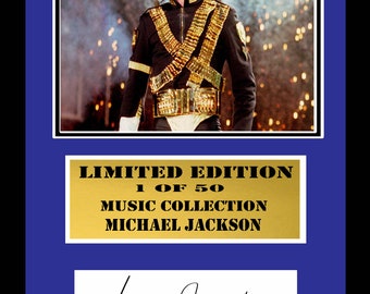 May include: A limited edition print of Michael Jackson, numbered 1 of 50. The print features a black and white photo of Michael Jackson wearing a black jacket with gold accents and a gold belt. The print is framed in a blue and gold frame. The print is signed by Michael Jackson.