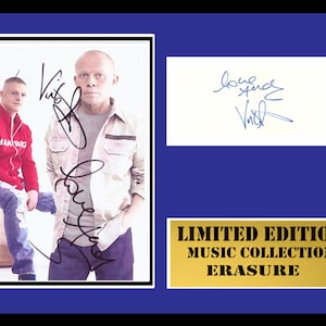 May include: A framed photograph of two men, one wearing a red jacket and the other a white shirt, with their signatures. The frame has a gold plaque that reads "LIMITED EDITION MUSIC COLLECTION ERASURE".