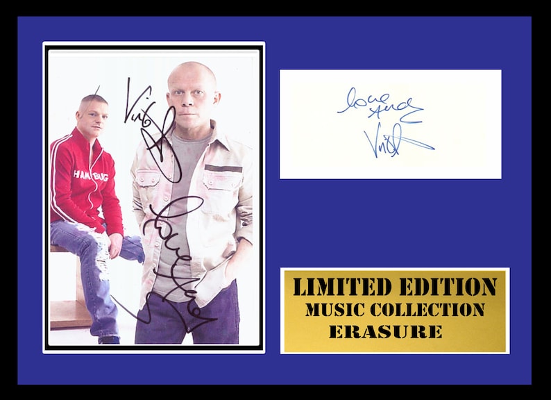 May include: A framed photograph of two men, one wearing a red jacket and the other a white shirt, with their signatures. The frame has a gold plaque that reads "LIMITED EDITION MUSIC COLLECTION ERASURE".