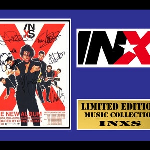 May include: A framed poster of the band INXS with their signatures. The poster features a red X with the band members standing in front of it. The poster is titled "The New Album" and includes the text "11 Tracks Including 'Suicide Blonde' Produced by Chris Thomas". The poster also includes a UK tour schedule for November and December 1998. The frame is blue with a gold plaque that reads "Limited Edition Music Collection INXS".