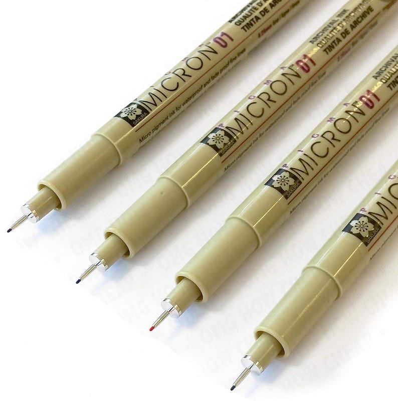May include: Three Sakura Micron 01 pens, a popular choice for artists and illustrators, are shown lying on a white surface. The pens are beige with black lettering and a black and white flower logo. The pens have a fine point tip.