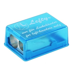 May include: A transparent turquoise pencil sharpener with two holes. The top of the sharpener has the word "Lefty" in white script, along with text that reads "nur für Linkshänder for left-handers only."