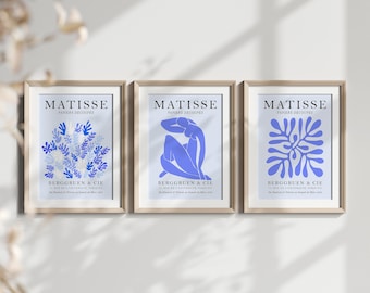 May include: Three framed prints of Matisse's "Papiers Découpés" artwork. The prints feature a blue and white floral design, a blue female figure, and a blue abstract design. Each print has the text "MATISSE" and "PAPIERS DÉCOUPÉS" at the top and "BERGGRUEN & CIE" at the bottom.