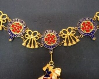 May include: A gold chain with blue and red enamel medallions featuring a red rose and the text "Honi Soit Qui Mal Y Pense". A pendant with a knight on horseback is attached to the chain.