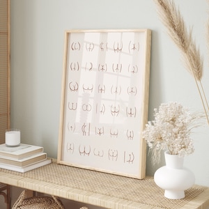 May include: A framed print with a light pink background and brown text. The text is a series of symbols and letters. The print is hanging on a wall above a light brown wooden bench with a woven rattan top. There are two woven baskets on the bench and a white vase with dried white flowers on the bench.