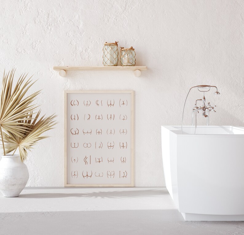 May include: A white bathroom with a freestanding bathtub, a wooden shelf with two glass jars, and a framed print with a pattern of abstract symbols. The print is in a light wood frame.