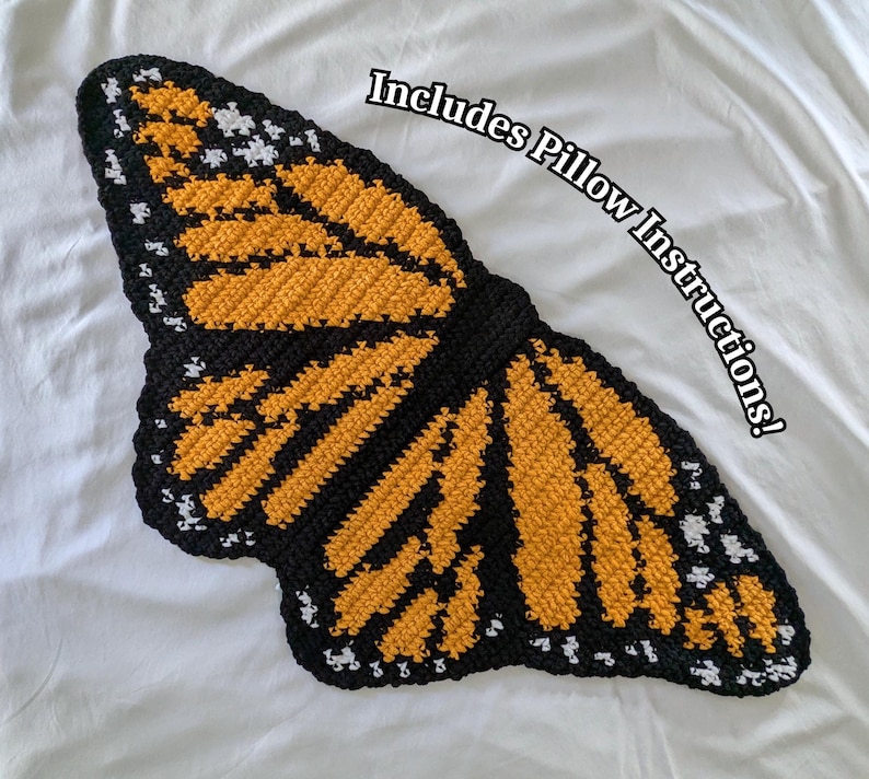 Peut inclure: Un coussin en forme de papillon crochet&eacute; en noir, jaune et blanc. Le coussin est en forme de papillon avec ses ailes d&eacute;ploy&eacute;es. Le texte "Includes Pillow Instructions!" est &eacute;crit en blanc sur fond noir.