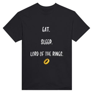 Könnte beinhalten: Schwarzes T-Shirt mit weißem Text, der "Essen. Schlafen. Der Herr der Ringe." lautet und einer goldenen Ringgrafik.