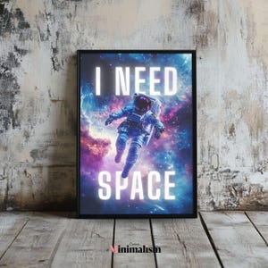 Könnte beinhalten: Gerahmter Kunstdruck mit einem Astronauten im Weltraum vor einem bunten Nebelhintergrund. Der Text "I NEED SPACE" ist in Weiß geschrieben. Ein dekoratives Wandbild für Weltraumfans.