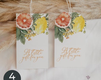 Puede incluir: Dos etiquetas de regalo rectangulares de papel con cordel blanco, con una ilustración en acuarela de una rodaja de pomelo, un limón amarillo y hojas verdes. El texto A little gift for you está impreso en cursiva dorada.