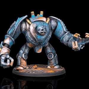 Peut inclure: Figurine de robot miniature détaillée avec une apparence métallique patinée. La figurine est principalement bleue avec des accents couleur rouille et présente un motif de crâne sur la poitrine. Elle repose sur une base circulaire avec une surface texturée.