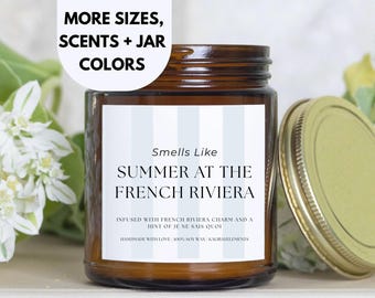 May include: A brown glass candle jar with a white label that reads "Smells Like Summer at the French Riviera". The label has a light blue and white striped background. The candle is infused with French Riviera charm and a hint of "je ne sais quoi". It is handmade with love, 100% soy wax, and Kaluavelements.
