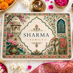 May include: A rectangular serving tray featuring a cream-colored center with the text SHARMA FAMILY in dark green. The design includes a decorative arch, a detailed elephant with a red blanket, a lotus flower pot, and an ornate border.