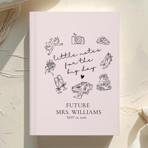 May include: A light pink wedding notebook with black line art illustrations of wedding-related icons, including rings, a cake, and a car. The text "little notes for the big day" is written in cursive. The notebook is personalized with the text "FUTURE MRS. WILLIAMS MAY 10, 2026."