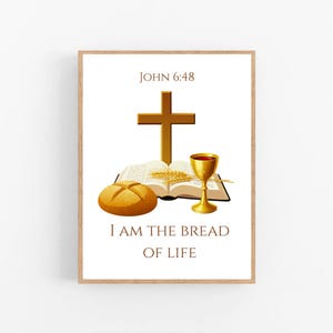 Peut inclure: Une affiche encadrée avec des symboles religieux. Une croix dorée surplombe un livre ouvert, du blé, un calice et un pain. Le texte "John 6:48" est en haut et "I AM THE BREAD OF LIFE" en bas.